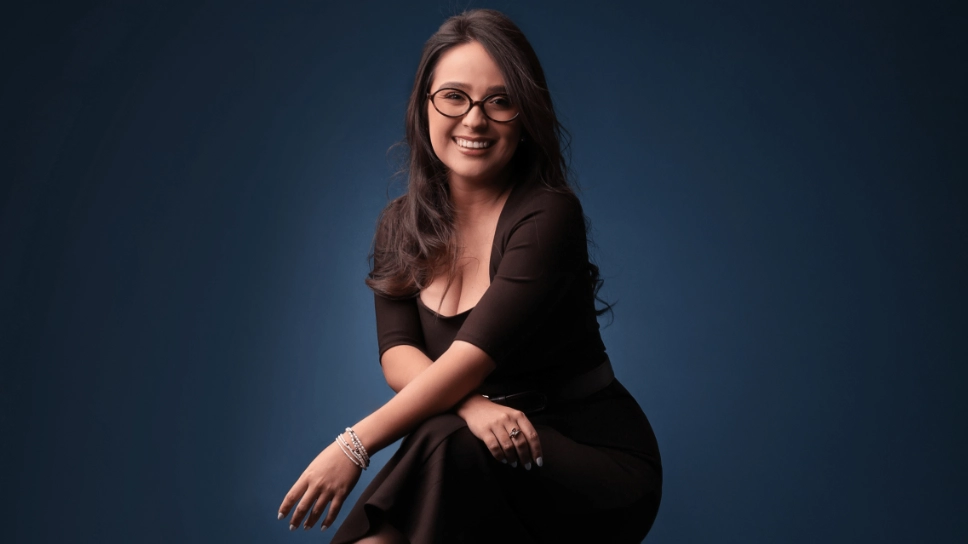 Retrato profesional de Verónica Chávez sonriendo sobre un fondo oscuro.